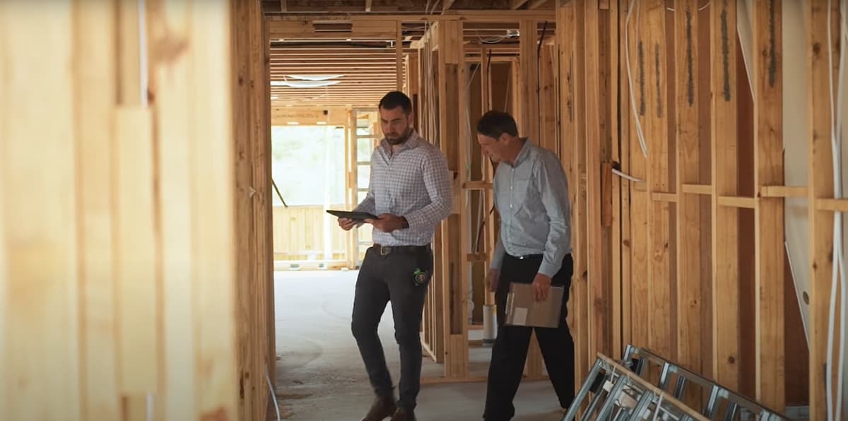 two people walking through a frame inspection after rough ins