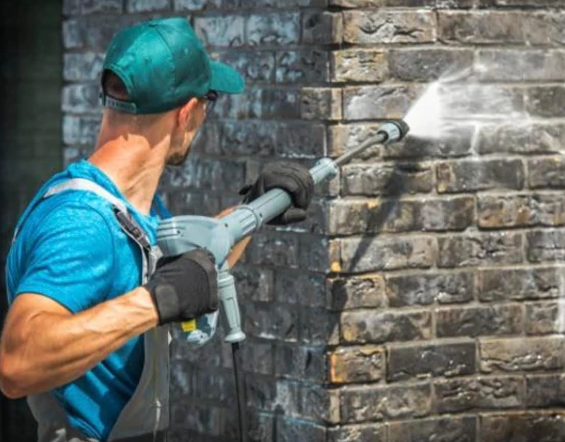 a man pressure washing brickwork