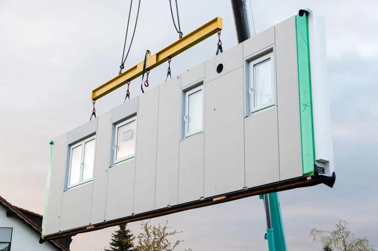 wall panel lifted by a aqua coloured crane boom